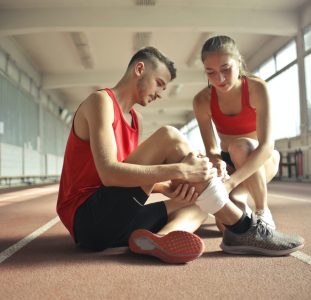 woman-helping-sportsman-with-injury-during-cardio-training-3760275