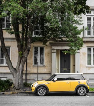 yellow-mini-cooper-parked-beside-white-concrete-building-457418
